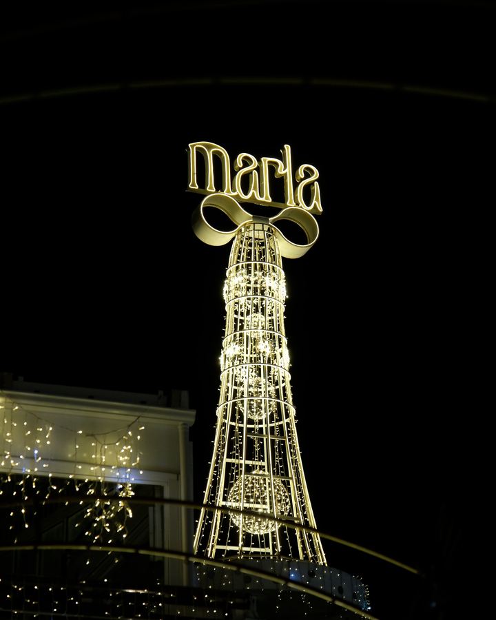 Gece bahçede aydınlatılmış Marla kulesi