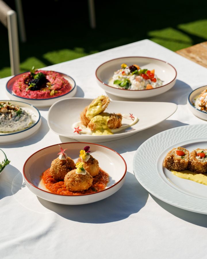 Yukarıdan uzun masada dizili meze ve ara sıcak tabakları