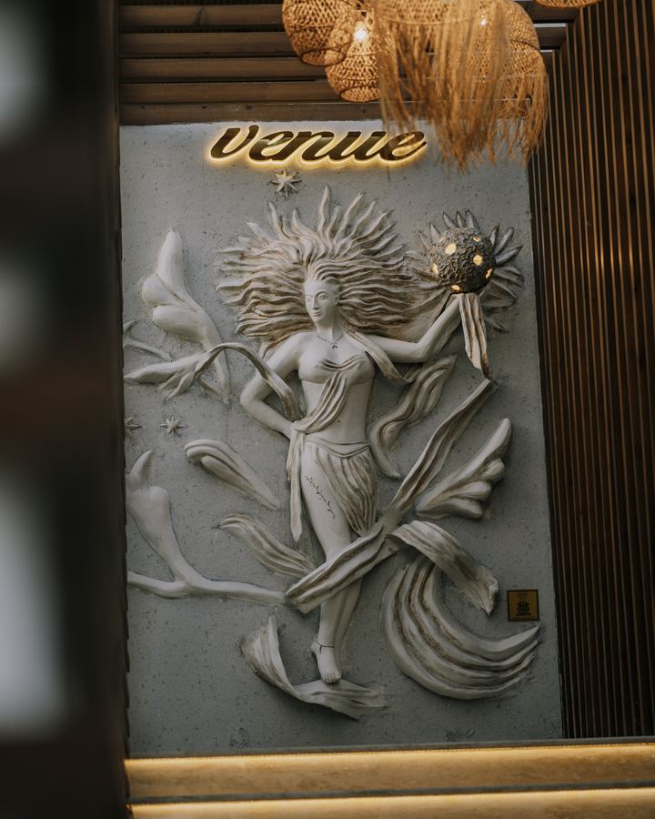 Duvarda kabartma pano ve üstünde altın renkli tabela